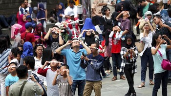 Para warga melihat gerhana di Planetarium Jakarta. Foto: AP Photo/Tatan Syuflana