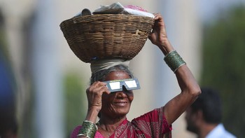 Tidak hanya anak muda, para orang tua di India pun tidak melewatkan prosesi Gerhana Matahari. Foto: AP Photo/Mahesh Kumar A