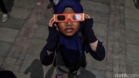 Seorang anak menggunakan kacamata khusus saat melihat Gerhana Matahari Parsial di kawasan Taman Ismail Marzuki, Jakarta.