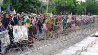 Massa menyampaikan aspirasinya di depan kawat berduri yang dipasang membentang sepanjang jalan di depan konsulat jendral (konjen) Republik Rakyat China, Jl Mayjen Sungkono, Surabaya.