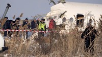 Bagian depan pesawat hancur karena menabrak sebagian rumah warga. Para petugas berusaha mengevakuasi pesawat. (AP Photo/Vladimir Tretyakov)