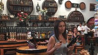 Nenek satu cucu ini sedang asyik santai di bar. Ia terlihat menikmati segelas wine sambil memegang botol wine. Foto: instagram @svetlanagass