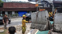 Petugas Bina Marga Kecamatan Kebayoran Baru menurunkan pembatas beton (moveable concrete barrier (MCB)) di pertigaan Apotik Senopati, Jakarta Selatan, Sabtu (28/12/2019).