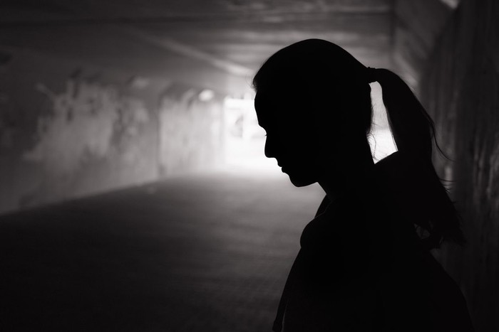 Ilustrasi wanita sedih Depressed sad young female standing in a dark tunnel