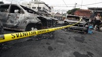 Polisi berjaga di sekitar bangkai mobil yang dibakar massa di Asrama Brimob, Jakarta. Mobil itu sebelumnya dibakar oleh massa dalam bentrok pada 21 Mei 2019 dini hari. Pradita Utama/detikcom.