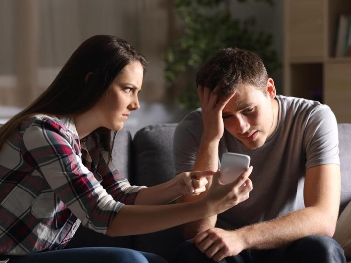 1078159390 Loving young husband hold crying wife hand showing empathy and support, millennial couple sit on couch at home reconcile after fight, caring man making peace with beloved woman. Relationships concept