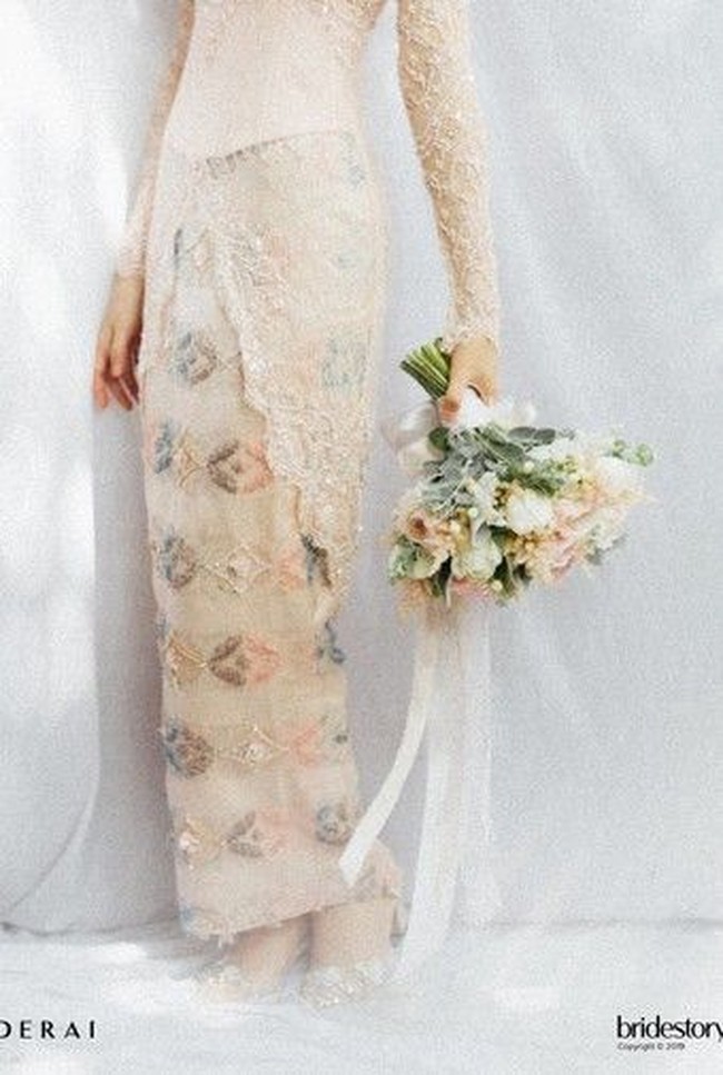 Saat lamaran, Isyana Sarasvati memakai kebaya dan kain bernuansa peach. Ini detail busana dari perancang Winny Adam tersebut. Foto: Bridestory