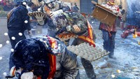 Potret warga Kota Ibi, saling melempar telur busuk dan tepung dalam tradisi Els Enfarinats yang digelar pada Sabtu (28/12) lalu.