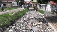 Besarnya volume sampah ini bisa dilihat dari permukaan saluran irigasi yang tertutup sampah sepanjang 500 meter.