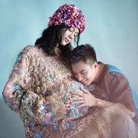 Berpose bersama sang suami, Baim Wong, Paula tampil glamour namun romantis dalam balutan gaun karya desainer Mel Ahyar. Sedangkan topi bunga yang menghiasi kepalanya karya dari Nina Nasution Floral. Foto: Dok. Instagram @dierabachir