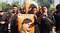 Menggunakan pakaian hitam dan membawa poster yang berisi wajah Ahmad Dhani. Foto: Farih/detikcom