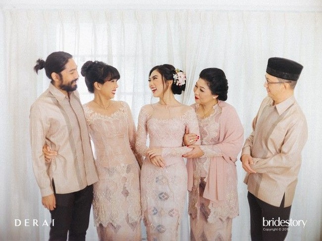 Isyana Sarasvati dan keluarga tampil kompak pakai memakai busana bernuansa sama. Acara lamaran Isyana pun tampil hangat. Foto: Bridestory
