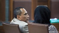 Elviyanto (kiri) dan Mirawati Basri (kanan) mendangarkan dakwaan yang dibacakan jaksa.