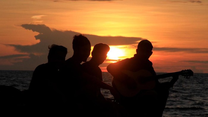 Sejumlah warga menikmati sunset atau matahari terbenam akhir tahun 2019 di Pantai Ampenan, Mataram, NTB, Selasa (31/12/2019). Taman Pantai Ampenan menjadi salah satu lokasi alternatif warga Mataram untuk melewati malam pergantian tahun. ANTARA FOTO/Ahmad Subaidi/wsj.