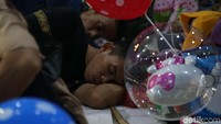 Seorang warga tertidur sambil menunggu hari berganti.