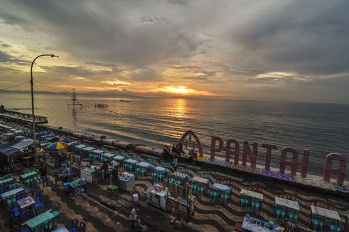 Sejumlah warga menikmati sunset atau matahari terbenam akhir tahun 2019 di Pantai Ampenan, Mataram, NTB, Selasa (31/12/2019). Taman Pantai Ampenan menjadi salah satu lokasi alternatif warga Mataram untuk melewati malam pergantian tahun. ANTARA FOTO/Ahmad Subaidi/wsj.