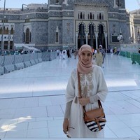 Tampil sederhana saat umrah, pembawa acara berita yang dikenal dengan sikap tegas ini mengenakan hijab segi empat. Najwa Shihab menggunakan hijab warna pink pastel yang dililit rapi ke belakang dan gamis warna putih dengan manset. Foto: instagram @najwashihab
