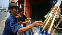 Seorang warga membeli terompet kertas yang akan dibunyikan saat malam pergantian tahun nanti.