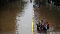 Ojek gerobak laris manis saat banjir melanda kawasan tersebut.