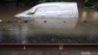 Mobil yang terparkir di samping rel juga ikut terendam hampir separuh badan mobil tersebut.