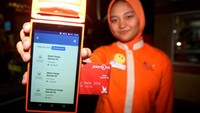 Seorang petugas menunjukan salah satu proses pembayaran non tunai dengan menggunakan merchant dan kartu Bank DKI di Ancol. Foto: dok. Bank DKI