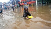 Motor tersebut didorong di tengah banjir setinggi pinggang orang dewasa.