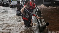 Ada juga yang nekat menyeberangi banjir dengan jalan kaki.