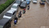 Pengendara sepeda motor nekat melintas tol karena Jalan Kebon Jeruk tak dapat dilewati akibat banjir.