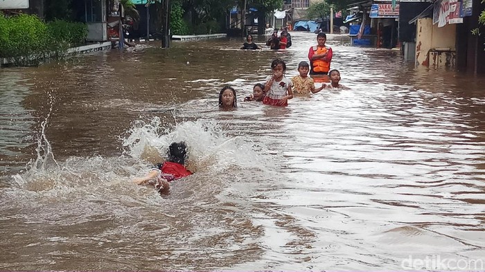 Anak-anak berenang di air banjir, apa risikonya? Foto: Farih/detikcom Anak-anak berenang di air banjir, apa risikonya? Foto: Farih/detikcom