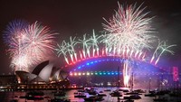 Salah satu kota favorit wisatawan di dunia juga merayakan pesta kembang api. Tepatnya di Harbour Bridge dan Opera House, Sidney, Australia. (AFP/Getty Images)