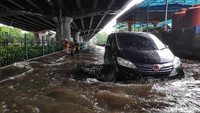Pengendara mobil nekat menerobos banjir di jalan samping Gerbang Tol Sunter. 
