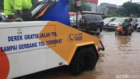Tampak mobil derek disiagakan di jalan yang terendam banjir.