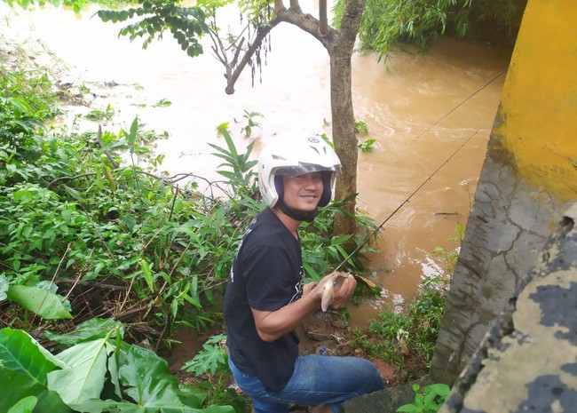 Dilanda Banjir, 5 Orang Ini Menikmati dengan Memancing Ikan