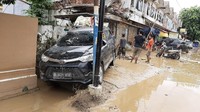 Sebuah mobil yang terseret banjir nyangkut di tembok dan tiang telepon. Salah seorang warga, Ratna (64) mengaku banjir kali ini paling parah selama ia tinggal di Kemang IFI Graha, Bekasi.