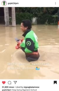 Di Tengah Banjir, Ojol Ini Tetap Semangat Antar Pesanan Makanan