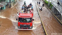 Mobil damkar juga digunakan untuk membantu warga menerobos banjir.