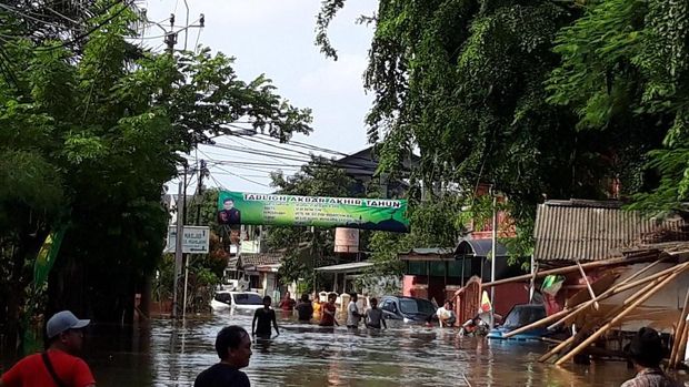 Penampakan dari jauh dua mobil yang terdampar di depan rumah warga.