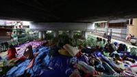 Dengan beralaskan terpal dan tikar warga nampak beristirahat di kolong jembatan tersebut.