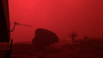 Saat malam hari, asap yang sangat pekat memantulkan warna merah dari api yang menyala membakar semak dan pepohonan. (brendanh_au/Twitter)