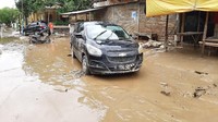 Warga masih membiarkan mobil di tengah jalan. Sebab mereka masih sibuk membersihkan rumah pasca banjir.