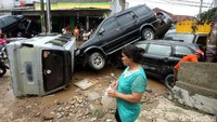 Derasnya arus banjir sanggup membuat sejumlah mobil terseret hingga menumpuk.