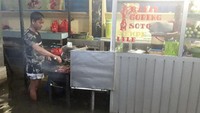 Pedagang yang satu ini tetap semangat mengejar rezeki.Air banjir yang menggenang setinggi betis tak dihiraukan. Ia tetap asyik memanggang ayam. Foto: istimewa