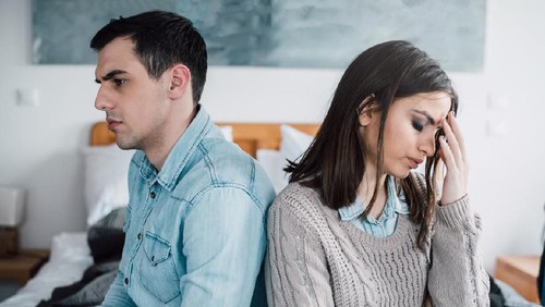 Two female friends talking on a bench in autumn park