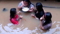 Setengah bagian badan empat wanita ini terendam air, tapi tangan dan mulutnya tetap sibuk makan. Sepiring makanan jadi santapan bersama.  Foto: istimewa