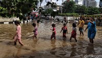 Sejumlah warga dan anak-anak melintas di kawasan Jalan Angkasa Kemayoran, Jakarta, yang terendam banjir, Kamis (2/1/2020).