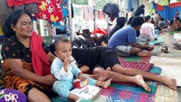 Mereka mengungsi untuk sementara waktu di halte tersebut hingga air yang merendam rumah mereka surut.