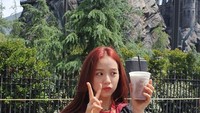 Tak hanya mencicipi es krim, Jisoo juga berpose dengan minuman di depan wahana Harry Potter saat mengunjungi Disney Land. Foto: Instagram @sooyaaa__
