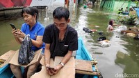 Genangan air yang cukup tinggi tersebut membuat warga memilih menggunakan perahu untuk beraktivitas maupun mencari logistik.