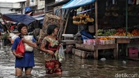 Meski genangan air masih terlihat cukup tinggi, tak sedikit pedagang maupun pembeli yang sibuk melakukan transaksi ekonomi di pasar tersebut.