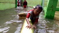 Anak-anak bermain di genangan banjir, Jumat (3/1/2020).